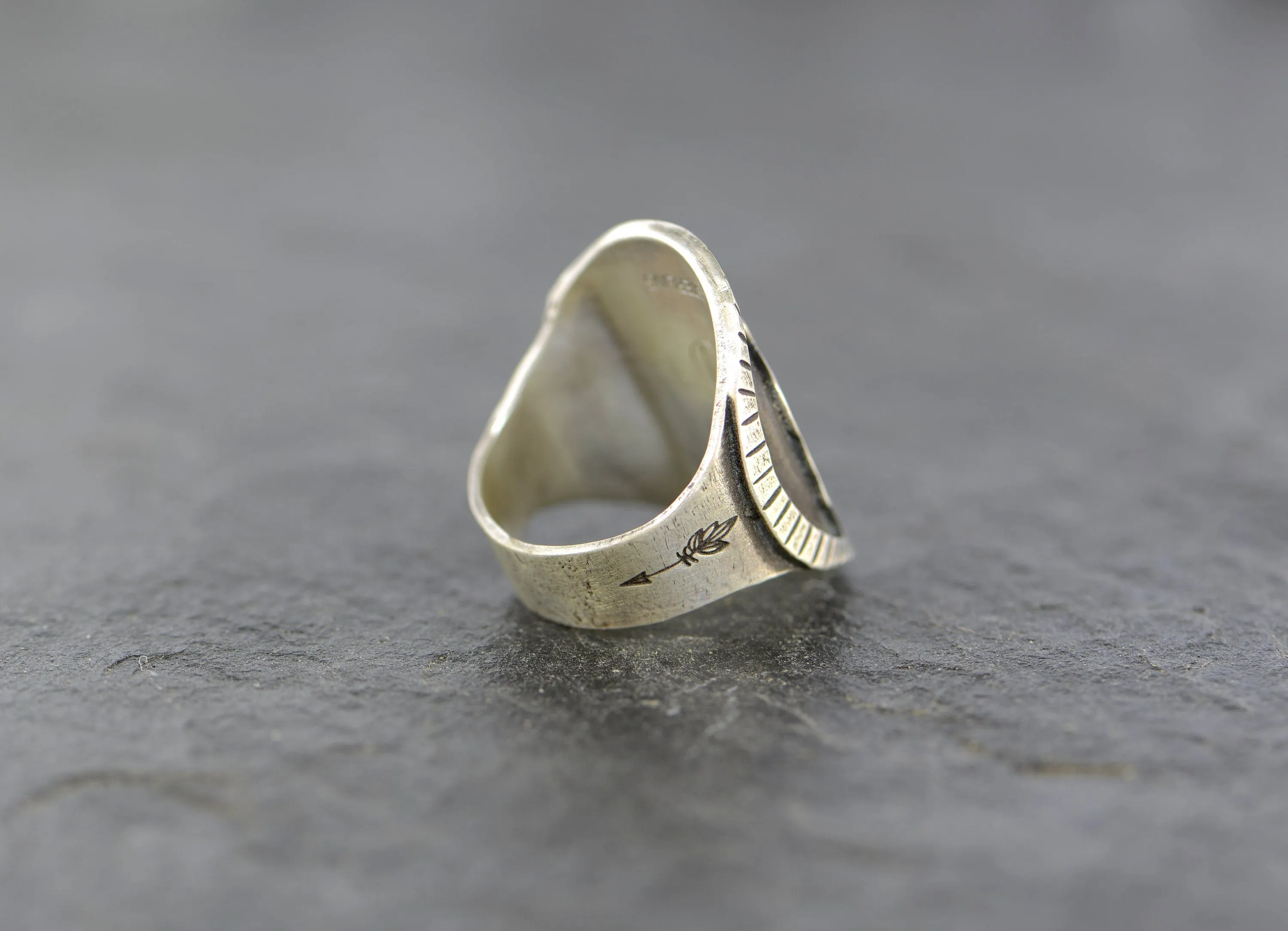Saddle ring with howling wolf and paw design  in sterling silver