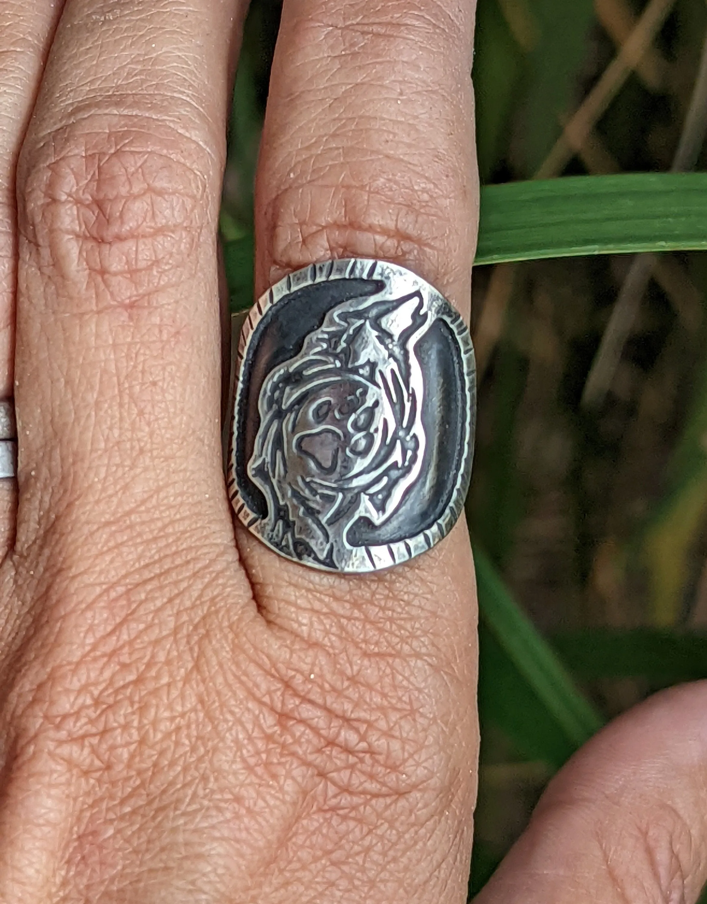 Saddle ring with howling wolf and paw design  in sterling silver